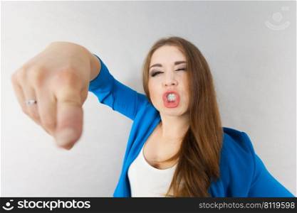 Young teenage woman having funny face expression. Face close up of lady pointing. Funny woman face close up pointing
