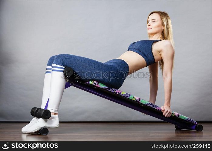 Young teenage woman training on bench for sit ups at home. Being fit and healthy, stomach muscles workout.. Woman training on bench for sit ups