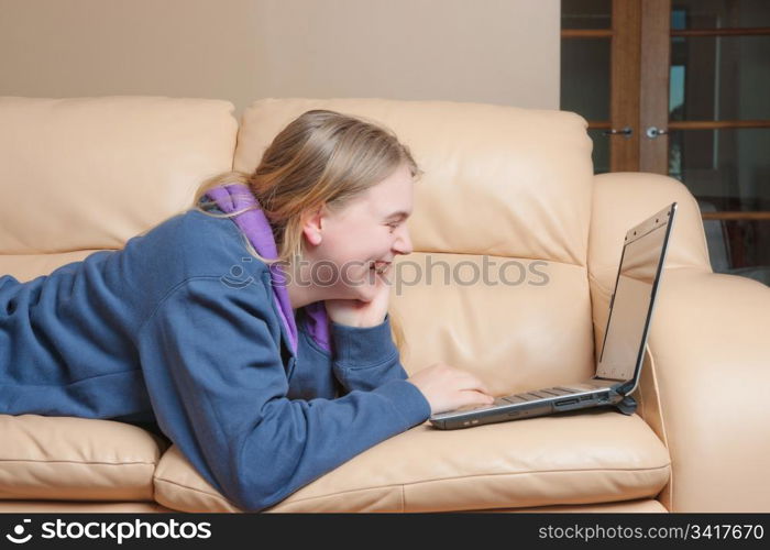 young teenage woman using a laptop on the sofa