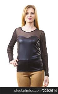 Young teenage woman wearing black leather top and brown skinny suede trousers. Female presenting fashionable outfit.. Young woman wearing fashionable outfit