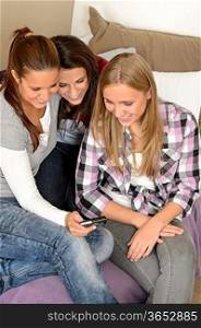 Young teenager girls looking at pictures on digital camera