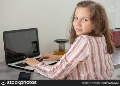 young teenager using a laptop at morning