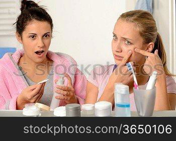 Young teenager with acne problem in the bathroom with friend