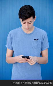 Young teenager with her cell phone and a blue wall background