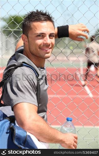 Young tennis player watching a game