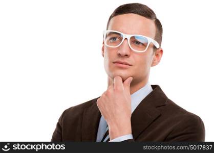 Young thoughtful businessman wearing glasses and holding chin on hand on white background