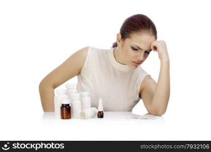 Young thoughtful woman looking at a group of pill bottles
