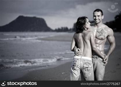 Young topless couple on beach