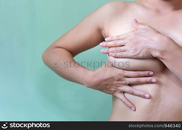 Young topless woman doing breast self-exam (BSE). Checking up breast changes, possible lumps, distortions or swelling. Breast cancer awareness.