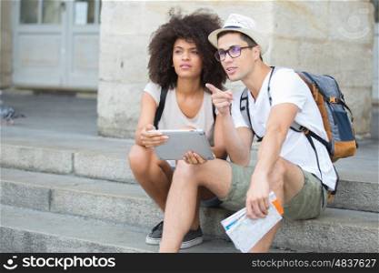 young tourist couple reading online city guide