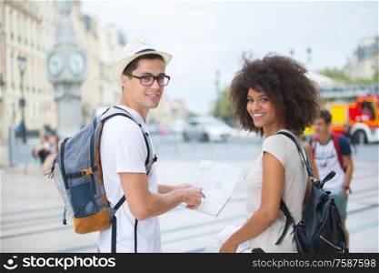 young tourist couple visiting bordeaux holding city map