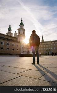 Young tourist on the cathedral square in Salzburg, sundown