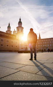 Young tourist on the cathedral square in Salzburg, sundown