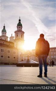 Young tourist on the cathedral square in Salzburg, sundown