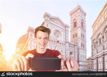 Young tourist taking selfie in front of Florence Cathedral Santa Maria del Fiore at sunrise, Tuscany, Italy