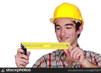 Young tradesman holding a try square