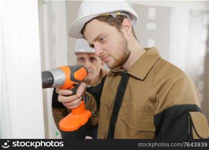 Young tradesman using cordless drill