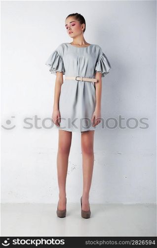 Young tranquil woman in light blue dress posing. Fashion style