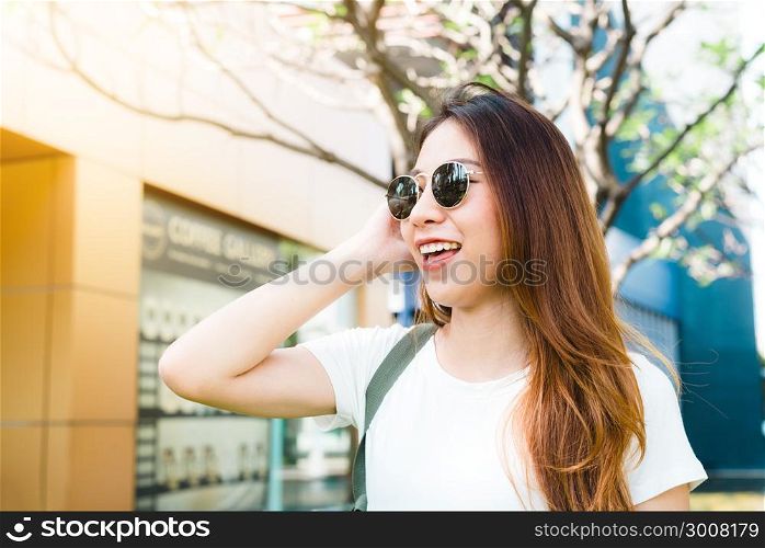 Young traveler asian woman admiring beautiful sunny narrow streets in Bangkok, Thailand. Sunny day in Bangkok, traveling in Asia. Backpacker photographer moving around city. Backpacker travel concept.