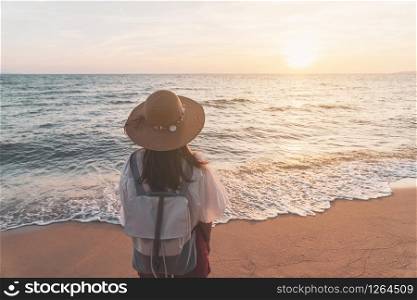 Young traveler woman relaxing on tropical beach at sunset, vacation and summer concept. Young traveler woman relaxing on tropical beach at sunset