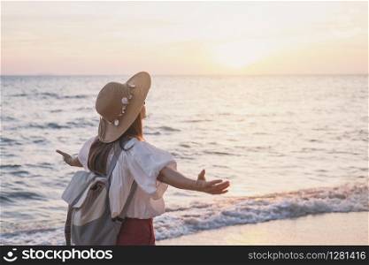 Young traveler woman relaxing on tropical beach at sunset, vacation and summer concept. Young traveler woman relaxing on tropical beach at sunset