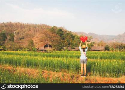 Young traveller in happiness moment standing on yellow flower field