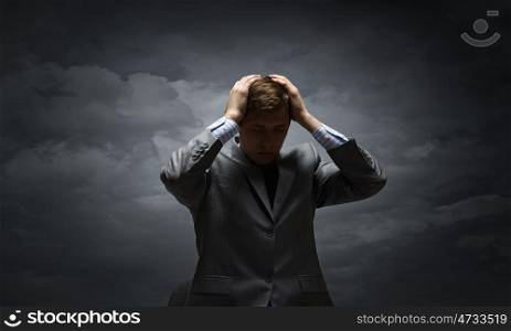 Young troubled businessman with hands on his head