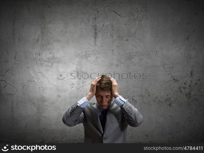 Young troubled businessman with hands on his head
