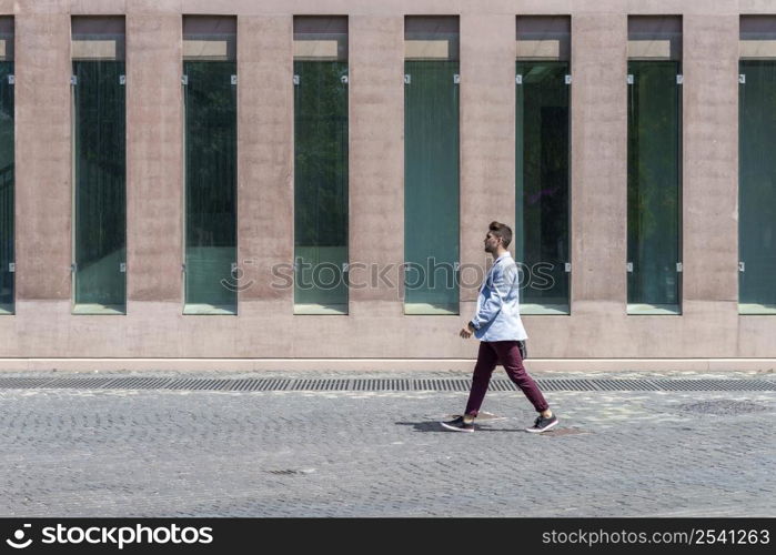 Young urban businessman professional walking in street wearing smart casual jacket. City lifestyle commute person walking.