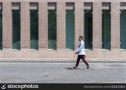 Young urban businessman professional walking in street wearing smart casual jacket. City lifestyle commute person walking.