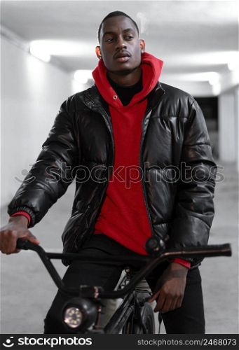 young urban man walking with his bike