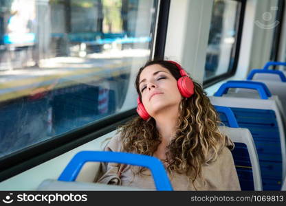 Young urban woman sleeping in a train travel beside the window. Modern people city lifestyle.