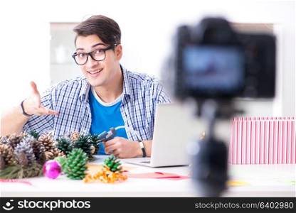 Young vlogger recording video doing christmas decoration