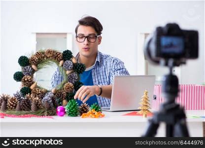 Young vlogger recording video doing christmas decoration