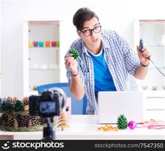 Young vlogger recording video doing christmas decoration. The young vlogger recording video doing christmas decoration