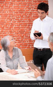 Young waiter taking an order in a restaurant