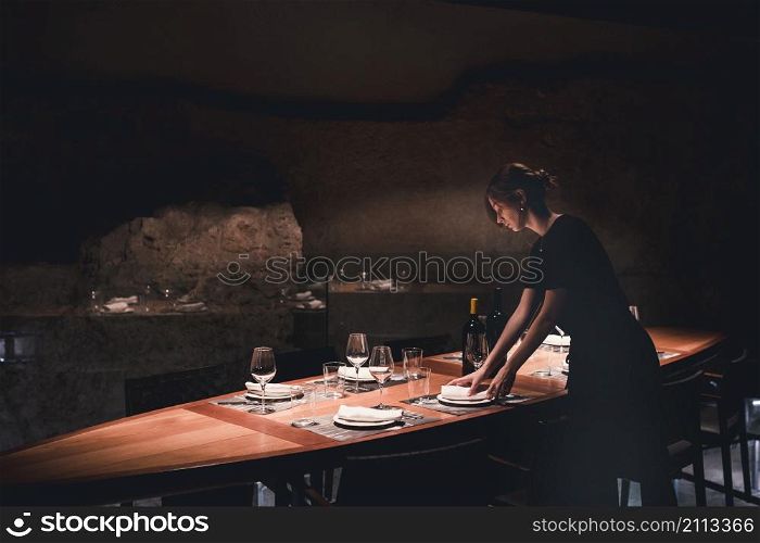 young waitress setting table