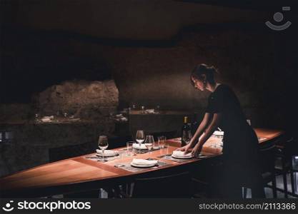 young waitress setting table
