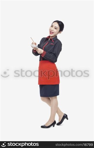 Young waitress taking an order, studio shot