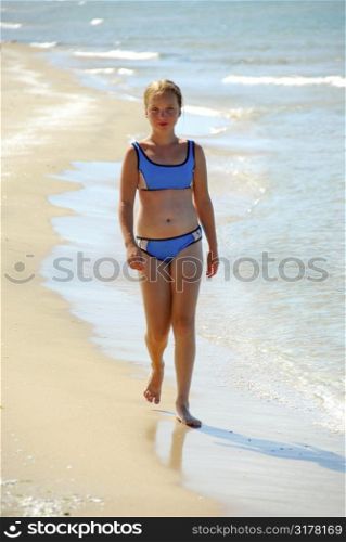 Young walking on a beach in shallow water