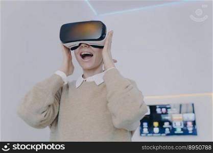 Young white woman is excited watching 3d vision in VR headset in office. Creative businesswoman working on project in cyberspace. Futuristic freelancer or student in vr eyewear indoors.. Young white woman is excited watching 3d vision in VR headset in office. Freelancer in vr eyewear.