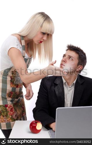 Young wife arguing with her husband because she?s working and his sitting at the laptop. He bit also from the forbidden fruit. Concept of the apple of discord.