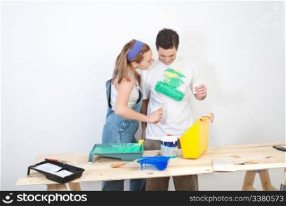 Young wife painting on t-shirt of husband