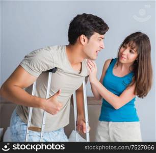 Young wife supporting husband on crutch after injury. The young wife supporting husband on crutch after injury