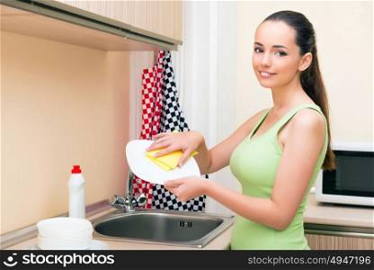 Young wife woman washing dishes in kitchen