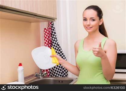 Young wife woman washing dishes in kitchen