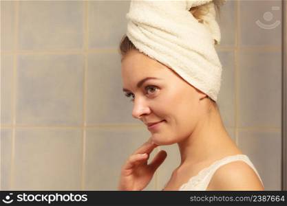 Young woman after morning shower in a bathroom, beautuful female wrapped turban towel. woman in towel on her head in bathroom