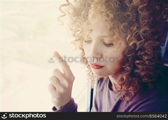 Young woman against a window