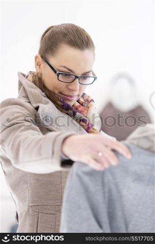 Young woman analyzing sweater in store