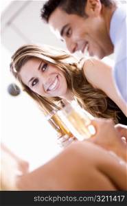 Young woman and a mid adult man holding champagne flutes